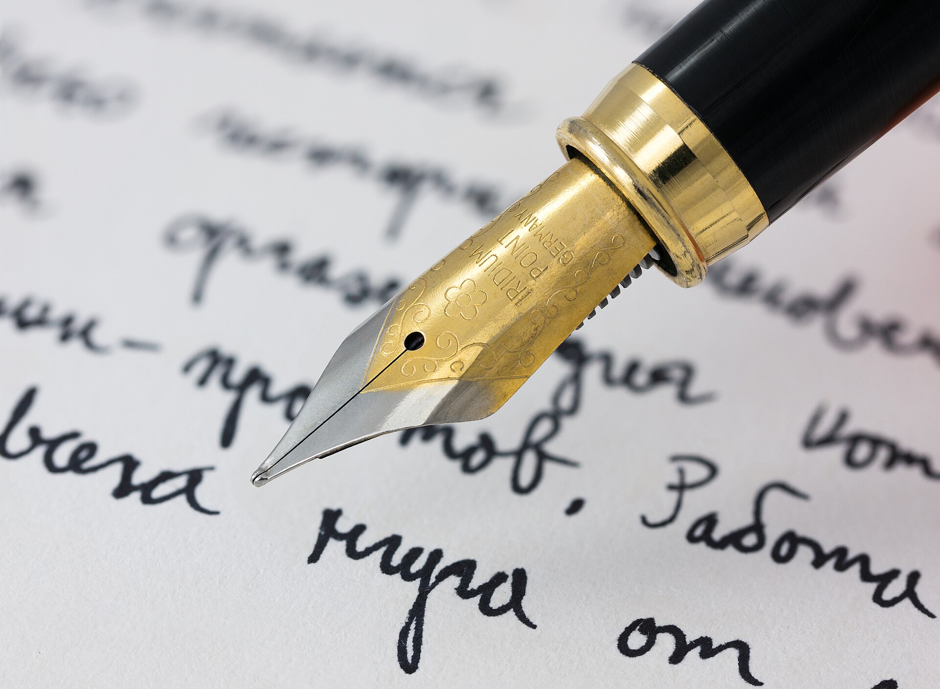 A gold fountain pen writes Cyrillic script on paper, illustrating the importance of compelling content.